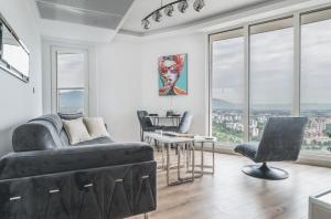 a living room with a couch and a table at Stylish 28F Gym Free Pkg Secured in Skopje
