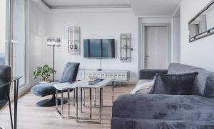 a living room with a couch and a tv at Stylish 28F Gym Free Pkg Secured in Skopje
