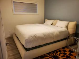 a bed with white sheets and pillows in a room at Grande maison excellente et luxueuse in Quebec City +6 photos