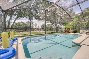 an indoor swimming pool with a clear glass enclosure at Southern Dunes Family Retreat Hot Tub and Game Room in Haines City
