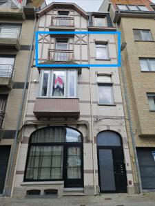 Un edificio de apartamentos con una bandera en la ventana. en Appartement cosy 2 chambres, en Wenduine