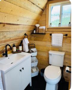 a bathroom with a white toilet and a sink at 9,000 feet Retreat Above It All in Guffey