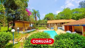 eine Villa mit Swimmingpool in einem Resort in der Unterkunft Pousada Corujão Quadra-SP in Quadra