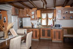 a kitchen with wooden cabinets and a table with chairs at Casa El Gabinete in Cariño