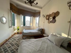 a bedroom with two beds and a window at Agora House for men only 仅限男性 in Alexandria