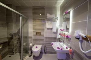 ein Badezimmer mit Waschbecken, Toilette und Dusche in der Unterkunft Kayı Hotel in Fethiye