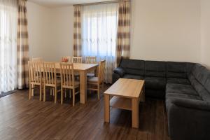 a living room with a couch and a table and chairs at Lesi Vendégház in Hajdúböszörmény