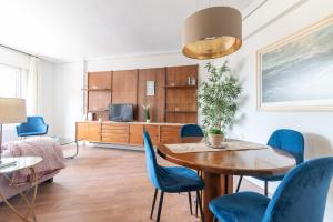 a living room with a table and blue chairs at Soleado apartamento en el centro de la ciudad in Santander +20 photos