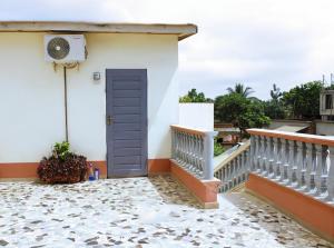 a house with a blue door and a balcony at Villa Magnifique in Abomey-Calavi
