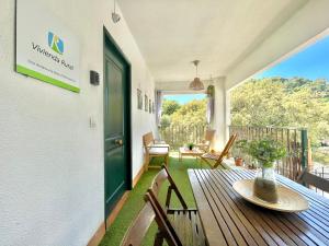 a porch with a wooden table and chairs and a green door at Casa Rural Una Ventana a la Sierra in Aracena