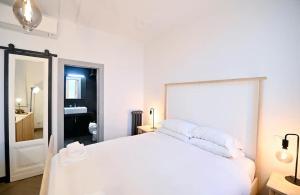a white bedroom with a white bed and a mirror at Why Not Apartment in Rome