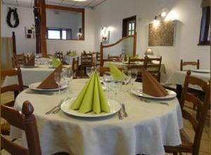 une salle à manger avec une table et un chiffon de table blanc dans l'établissement LOGIS - Auberge Du Colombier, à Guînes