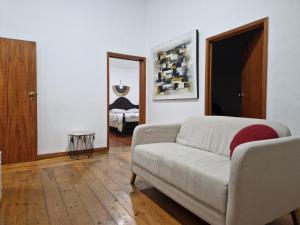 a living room with a couch and a mirror at Casa do Botelho in Évora