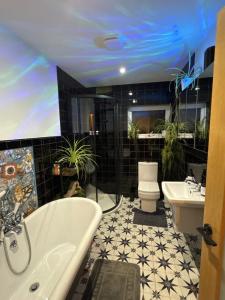 a bathroom with a tub and a toilet and a sink at Detached Home Close to the Beach Newquay in Saint Columb Minor +12 photos