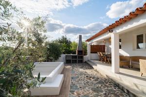eine Terrasse eines Hauses mit einem Sofa und einem Tisch in der Unterkunft Teal and Green - Alqueva Country House in Amieira