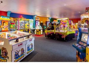 a room filled with lots of arcade games at Family Holiday Home with private terrace in Saint Osyth