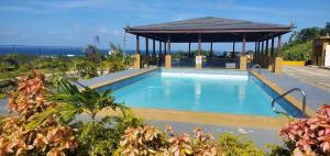a swimming pool with a gazebo in a garden at Chateau Bellview in Falmouth