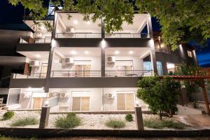 a white building with a lit up facade at Kipos Resort in Nea Peramos