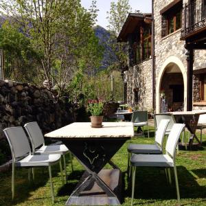 Hotel Casa Arcas في فيلانوفا: طاولة وكراسي في ساحة عليها نبات