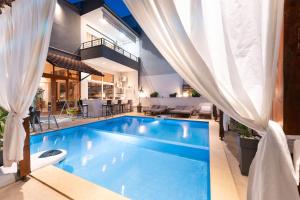 a swimming pool in the middle of a house at Kipos Resort in Nea Peramos