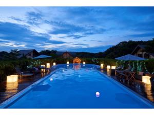 a swimming pool at night with tables and chairs at Fiore Shima - Vacation STAY 25654v in Shima