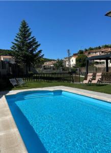 a large blue swimming pool in a yard at Apartamentos COVARRUBIAS 3 ESTUDIO in Covarrubias