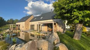 Horní Černá Studnice2domky的前面有池塘的砖房