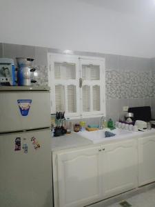 eine Küche mit einem weißen Kühlschrank und einer Spüle in der Unterkunft Dar MORTADA TATAOUINE in Tataouine