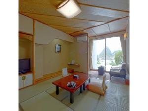 a living room with a table and a couch at Dogashima Onsen Hotel - Vacation STAY 55276v in Tago