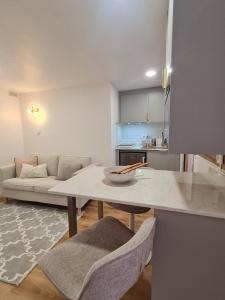 a kitchen and living room with a table and a couch at Alba Odeceixe - casa baixa in Odeceixe +24 photos