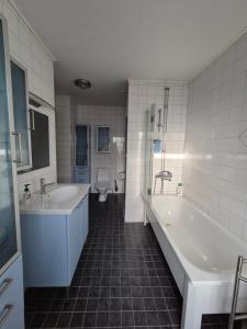 a bathroom with two sinks and a tub and a toilet at Vacker villa nära Kolmården och Norrköping in Åby +15 photos