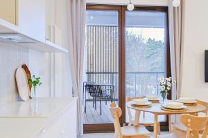 a kitchen and dining room with a table and a balcony at Yoga Zen, apartament z tarasem i widokiem na park in Łódź +34 photos