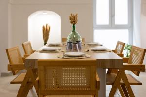 a dining room table with chairs and a vase at Donna Veneranda in Vieste