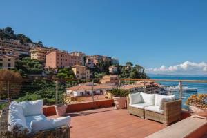 a balcony with chairs and a view of the water at Porto Santo Stefano Panoramic Penthouse in Porto Santo Stefano