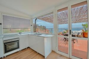 a kitchen with a sink and a stove at Porto Santo Stefano Panoramic Penthouse in Porto Santo Stefano