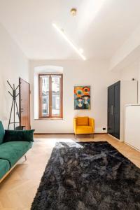 a living room with a green couch and a yellow chair at Italian Essence - Bergamo Center in Bergamo