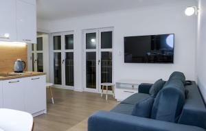 Una sala de estar con un sofá azul y una cocina. en Awesome Apartment In Ustka With Wifi, en Ustka