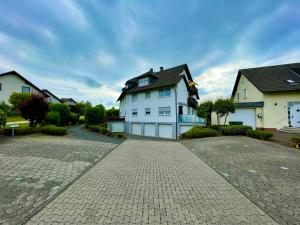 a white house with a black roof on a driveway at Ferienwohnung Auszeit in Attendorn