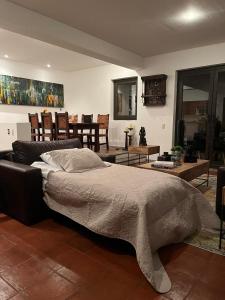 a bedroom with a bed and a living room at Cousy Condo in the historic center of San Miguel de Allende, incredible view, pool, BBQ, 3 blocks from the main parish in San Miguel de Allende