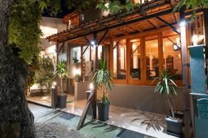 a building with potted plants in front of it at night at Kipos Resort in Nea Peramos