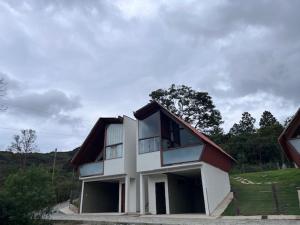 a white and red house with a roof at Chalé Por do Sol in Ouro Preto