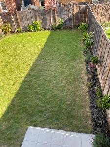 a backyard with a fence and a lawn at County Side Maidstone in Maidstone