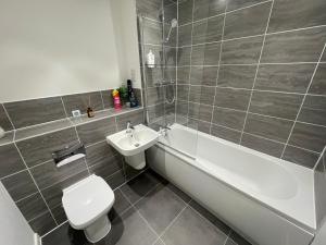 a bathroom with a toilet and a sink and a bath tub at County Side Maidstone in Maidstone +1 photo