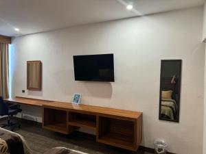 ein Wohnzimmer mit einem Fernseher an der Wand in der Unterkunft Hotel Los Valles Plus in Creel