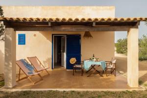 a patio with a table and chairs in front of a house at Casa Garrover - Calma entre Sabinas in Illes Balears