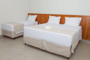 twee eenpersoonsbedden in een kamer met bij Novo Valle Hotel in Itinga