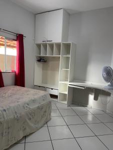 a bedroom with a bed and white cabinets at Imóvel amplo, bem ventilado e boa localização in Mucuri