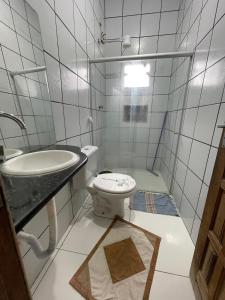 a bathroom with a toilet and a sink at Imóvel amplo, bem ventilado e boa localização in Mucuri +16 photos