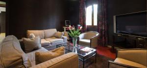 a living room with two couches and a television at Hostellerie St Vincent in Nuits-Saint-Georges