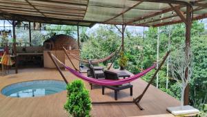 eine Hängematte auf der Terrasse eines Hauses in der Unterkunft Quinta Vacacional Oasis en Pedro Vicente Maldonado-Pichincha Ecuador in Pedro Vicente Maldonado